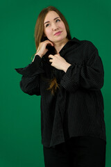 Confident young businesswoman adjusting her hair, exuding professionalism and style in a blue suit against a white background. High quality photo