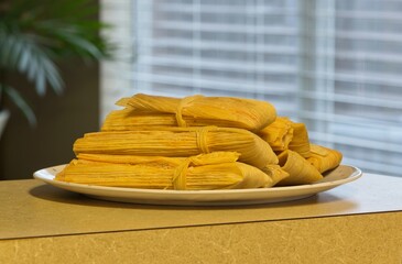 Fresh tamales on plate Mexican food Hispanic cooking domestic household countertop.