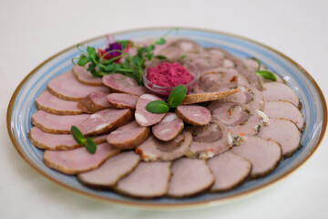This dish features thinly sliced roast meat arranged elegantly on a platter, complemented by crispy vegetable bites, offering a delightful contrast in texture and flavor. High quality photo