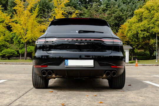 October 9, 2021, Seoul, South Korea - A black Porsche Macan S luxury SUV parked in a lot with autumn trees in the background.