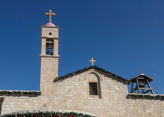 Nazareth, Israel, December 24, 2025, Bell tower and facade of the greek orthodox church of the annunciation under clear sky