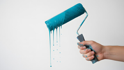 Hand holding paint roller with blue paint dripping