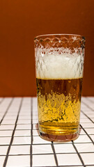 Glass of White Beer on Empty Tile Table. Beverage Indoor Closeup
