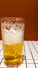 Glass of White Beer on Empty Tile Table. Beverage Indoor Closeup