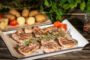 Barbecue pork tenderloin medallions with vegetables and herbs, close up
