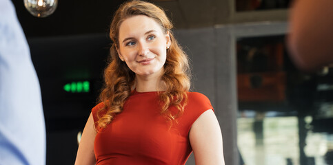 Confident young business professional woman smiling during a corporate networking event or after work social gathering. New year party, customer meeting or partnership