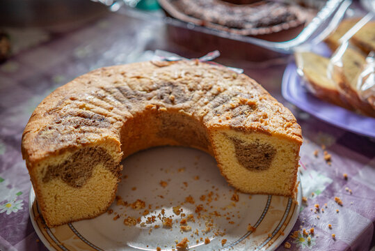 Close-up of a round marble sponge cake with the center piece removed, showcasing the soft texture and contrasting chocolate-vanilla pattern.