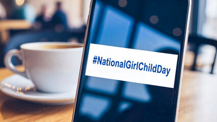 Smartphone displaying #NationalGirlChildDay hashtag with coffee cup  