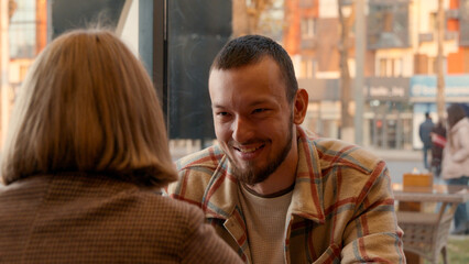 Man smiling at woman in a bright cafe