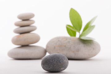 Close-up of balanced stones tower with green leaves suggesting tranquility and growth. Ideal for projects needing a serene and mindful touch.