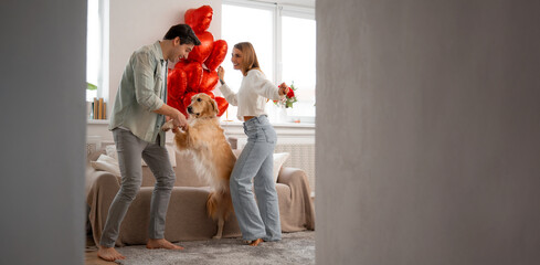 Joyful couple dancing with their dog at home, celebrating love, happiness and family connection.
