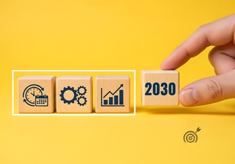 Wooden blocks displaying icons and the year two thousand thirty on a yellow background with a hand