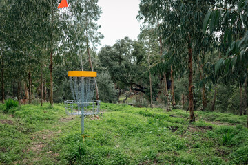 yellow disc golf basket with red flag