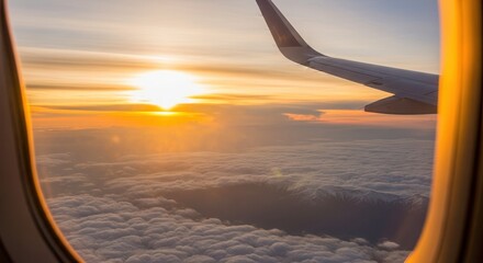 Airplane wing view from window over mountains and clouds at sunset. Sky and sunlight above foggy peaks. Scenic airline travel and business journey.