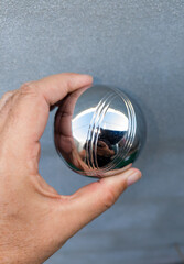 Holding a p&eacute;tanque ball in one hand, to appreciate its size