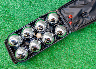 A set of p&eacute;tanque balls in its case, with a jack, a measuring cord, and a magnet for picking up the balls without bending over.