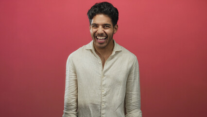 Obraz premium Man smiling showing teeth and laughing with clenched hands wearing linen shirt in studio; joy confidence.