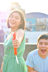 Happy latin siblings holding fruit ice.