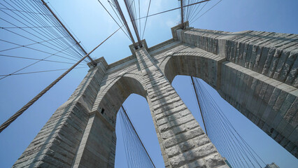 Fototapeta premium Brooklyn Bridge stone pillars captured from below highlighting structural details and grandeur