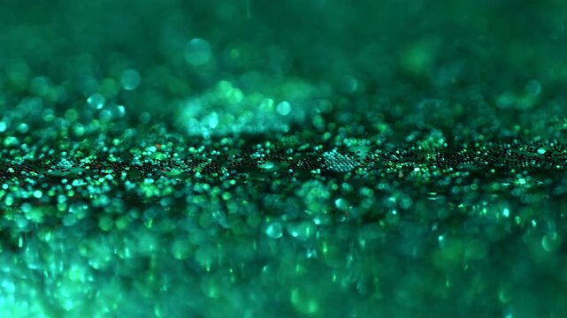 Abstract emerald green glitter bokeh background. Sparkling shimmering particles with soft blur and shallow depth of field. Luxury festive texture for holidays, celebration, beauty, cinematic titles.