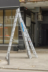 Tall Aluminium Free Standing Ladder in Front of Store at Street