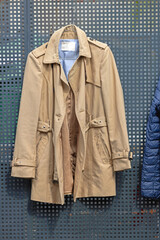 Beige Raincoat Hanging at Fence Classic Men Fashion