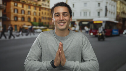 Naklejka premium Young hispanic man smiling on urban street with blurred city bus and historic buildings in background.