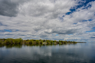Calm lake shoreline under dramatic cloudy sky