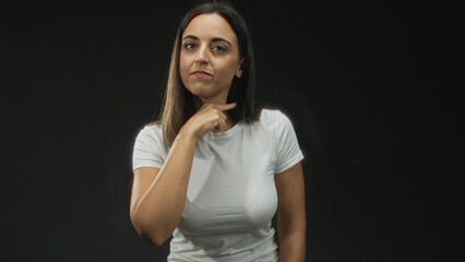 Woman pinches nose with index finger in studio wearing white tshirt, frontal closeup showing face...