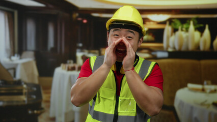 Man wearing safety vest and yellow helmet cheerfully shouting in a restaurant setting, blending casual dining with construction vibes in an unexpected indoor context.