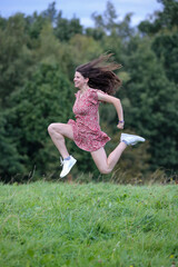 H&uuml;bsche Teenagerin h&uuml;pft und springt in der Natur