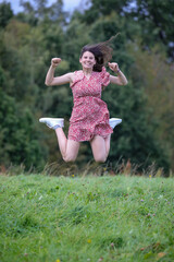 H&uuml;bsche Teenagerin h&uuml;pft und springt in der Natur