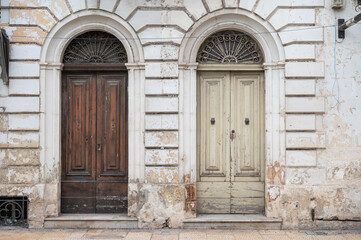 Authentic weathered house facades in Iz-Zeytun with ochre limestone walls, wooden doors and windows reflecting traditional Maltese architecture Iz-Zeytun, Malta, 10 DEC 2025.