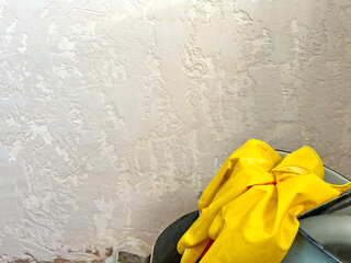 Renovating wall texture with yellow protective gloves