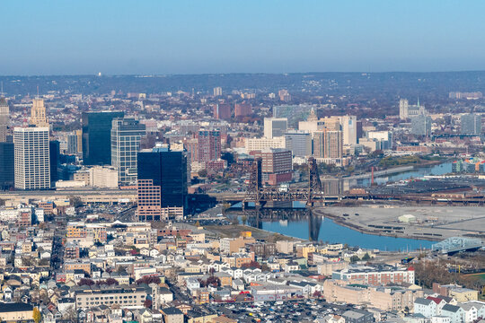 Aerial view of Newark, New Jersey shows a dense urban landscape with a mix of modern skyscrapers and older buildings. The  NJ Transit Dock Bridge over the Passaic River  and residential buildings