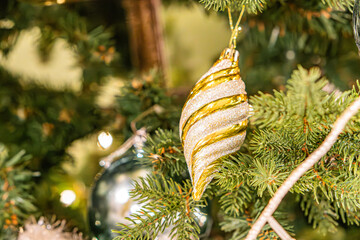 A festive Christmas tree with a golden ornament and circular decorations, illuminated from within by warm lights a