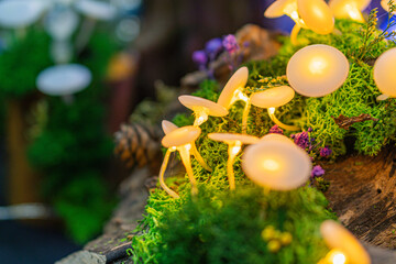 A rustic, festively lit wooden tree trunk with a natural wreath of green leaves and purple flowers Realistic style, irregularly arranged strings of yellow and white lights, slight below perspective,