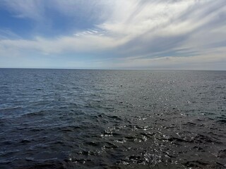 Open sea glittering dark blue waters and sky.