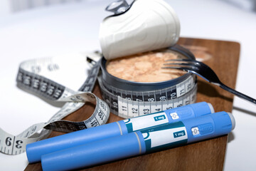 Weight loss concept featuring tuna fish and ozempic pen.