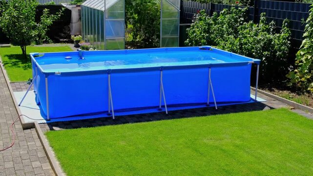 A large 2x4 meter swimming pool with clear water sits on a green lawn in the garden. A beautiful garden with a greenhouse and various plants provides a relaxing area for the whole family.