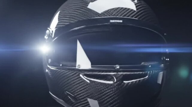 A detailed close-up shot emphasizes the advanced design and material of a high-performance protective helmet. The intricate weave of dark carbon fiber composites creates a strong, lightweight shell, h