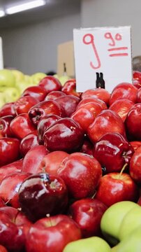 Tracking shot of different kind of ripe fruit on shelf in market. Red, yellow and green apples with price for them at Tel Aviv market, Israel