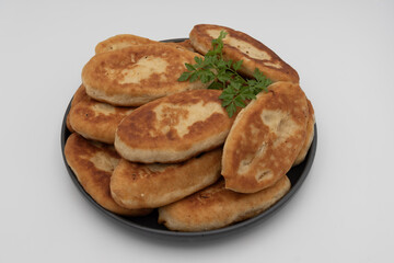 Traditional home baked fried potato pies with crispy crust and soft potato filling, classic домашняя выпечка served on plate, isolated on white background.
