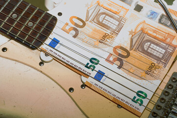Payment. Two 50 euro banknotes on a rock funky electric guitar