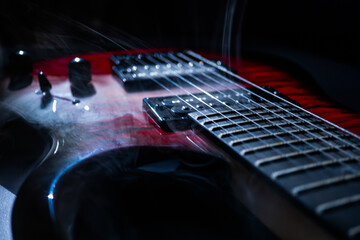 Close-up view of a red electric guitar against a dark background, pickguard reflecting subtle light Strings appear floating, conveying depth and dimension Taken from a low angle, focusing on the fr