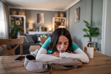 Exhausted female nurse sleeping on a table at home