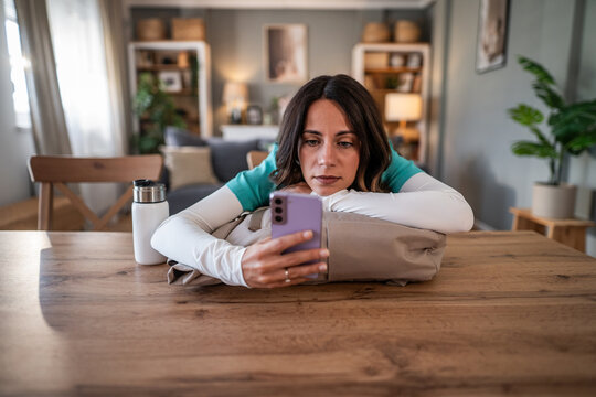 Overworked healthcare worker taking a break reading smartphone