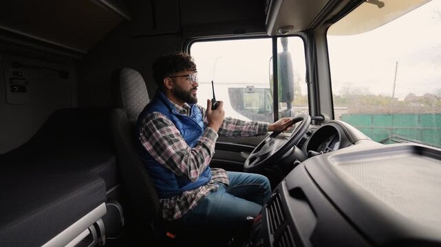 Truck driver communicating using walkie talkie inside cabin
