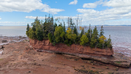 Aerial drone views at Burntcoat Head Park in Nova Scotia reveal extreme tidal forces, where low tide exposes forested islands and towering rock formations shaped by the world’s highest tides.