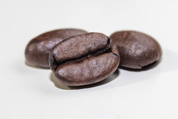 Roasted coffee beans macro close up on light background.
